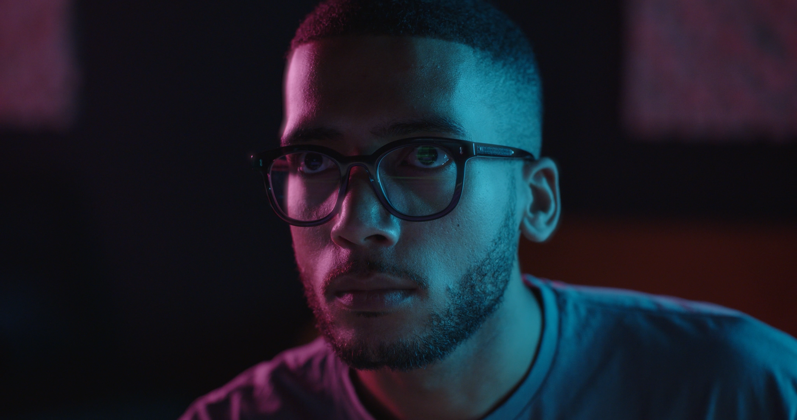 Man with glasses in pink and blue light for Bruker film