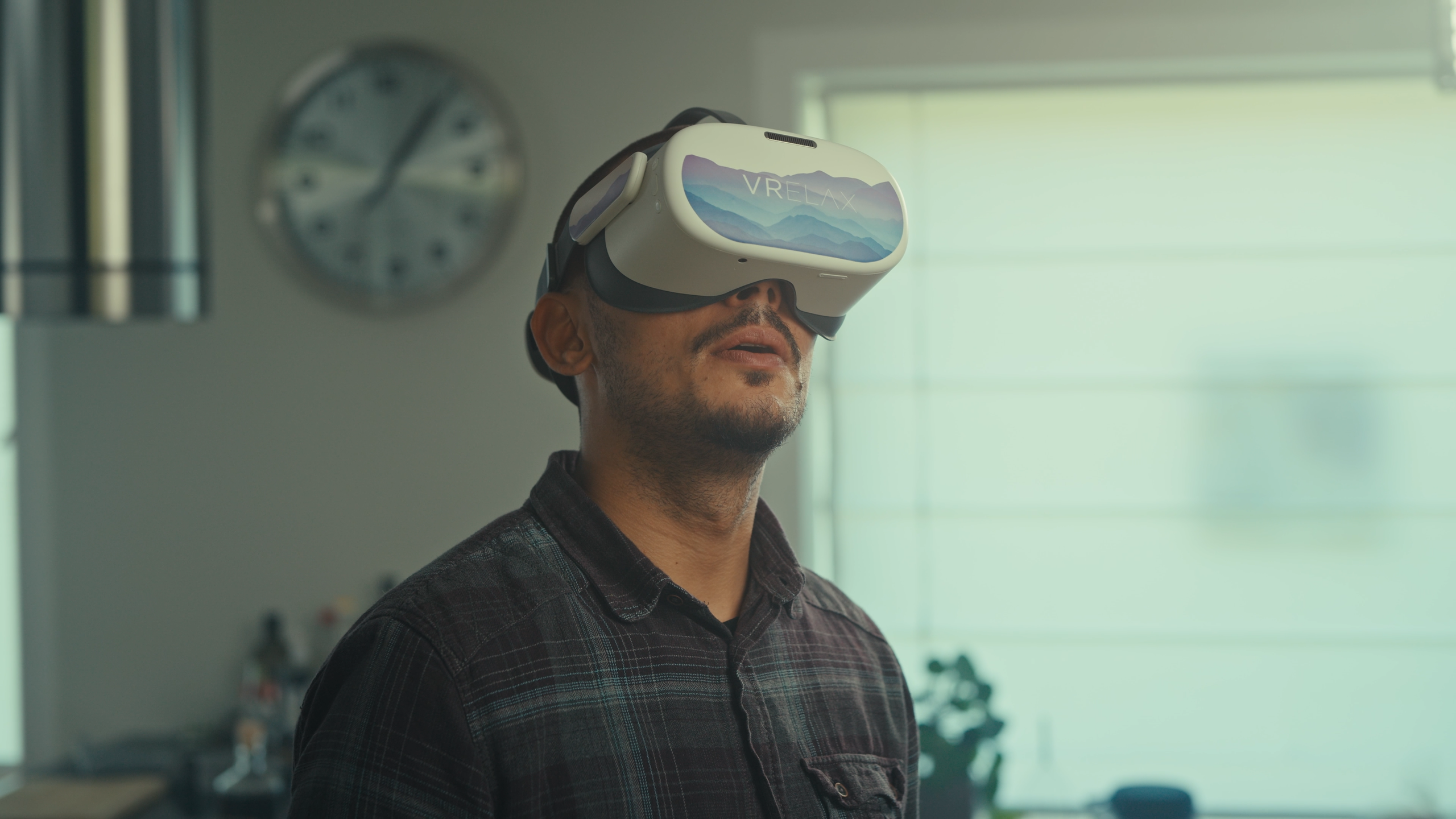 A man wearing a virtual reality (VR) headset in domestic surroundings, taken from Sensu.health's commercial video for VRelax