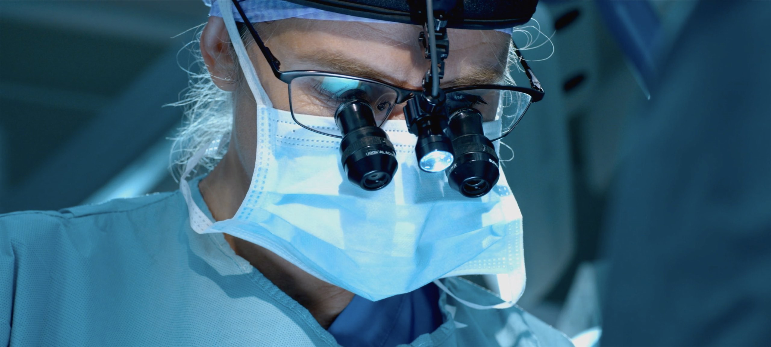 Surgeon wearing surgical loupe working.jpg