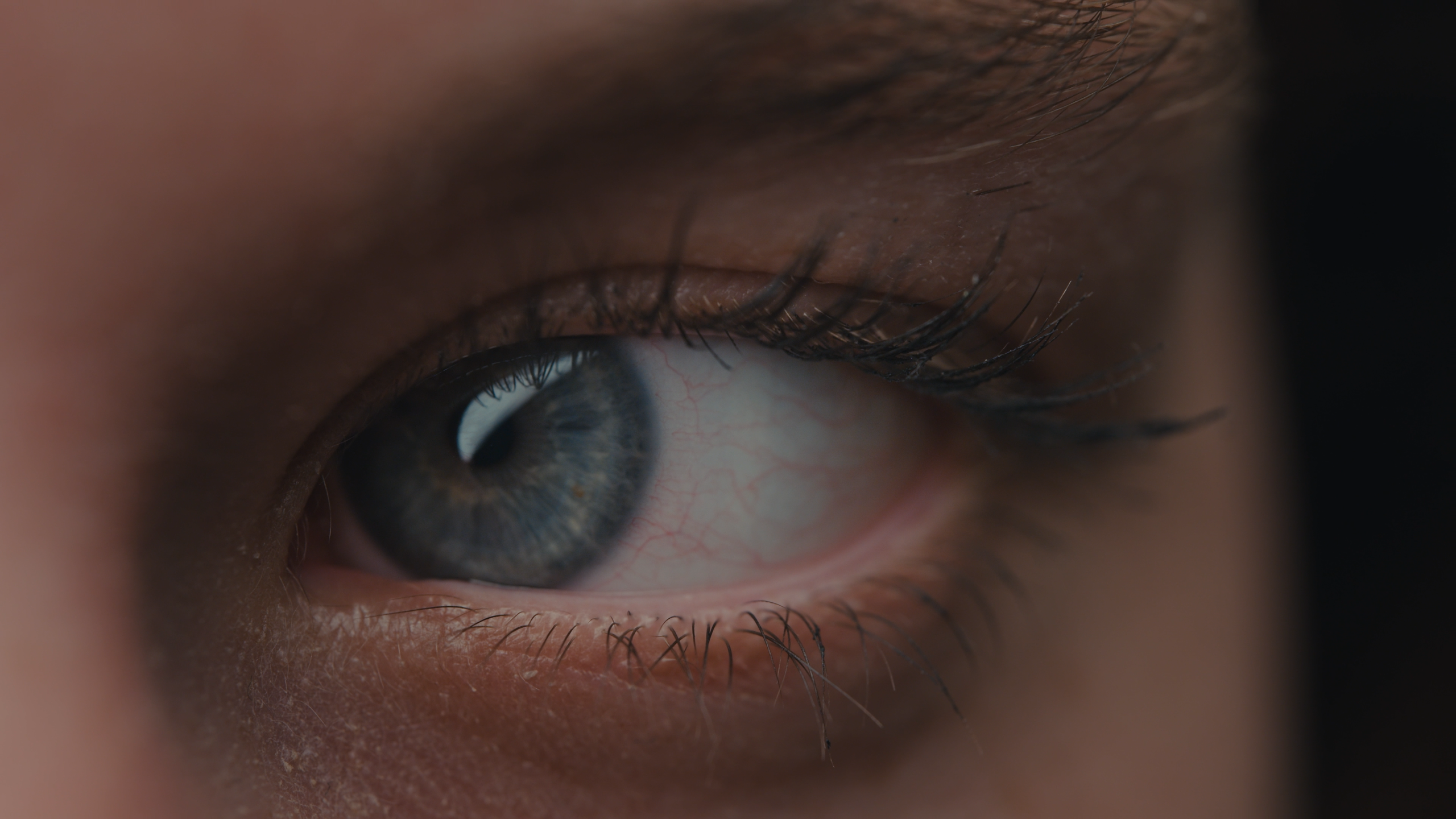 Close-up of the blue eye of a young woman looking sideways, taken from Sensu.health's commercial video for VRelax